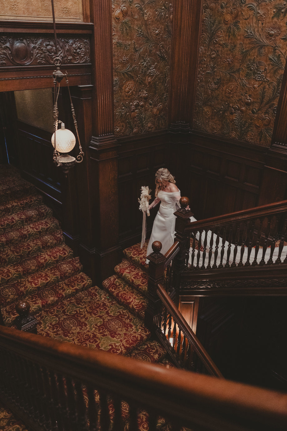 Bride walking down Norwood Hall Hotel's grand staircase